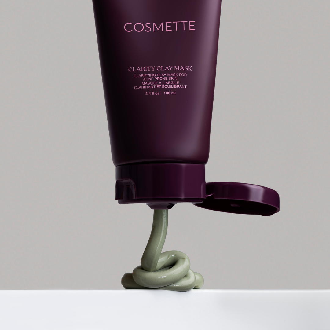 Cosmette Clarity Clay Mask tube with clay mask coming out on a gray background