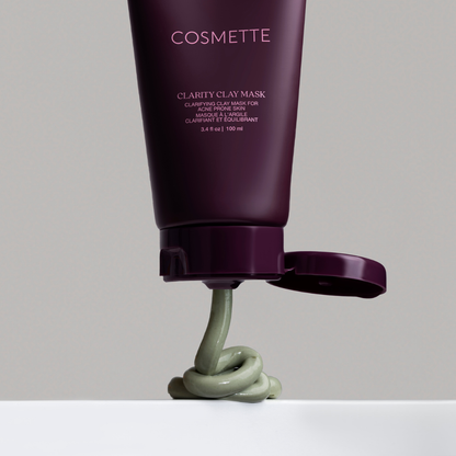 Cosmette Clarity Clay Mask tube with clay mask coming out on a gray background