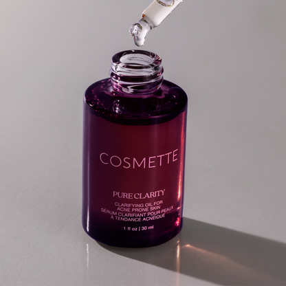 Cosmette Pure Clarity oil bottle with dropper on a gray background