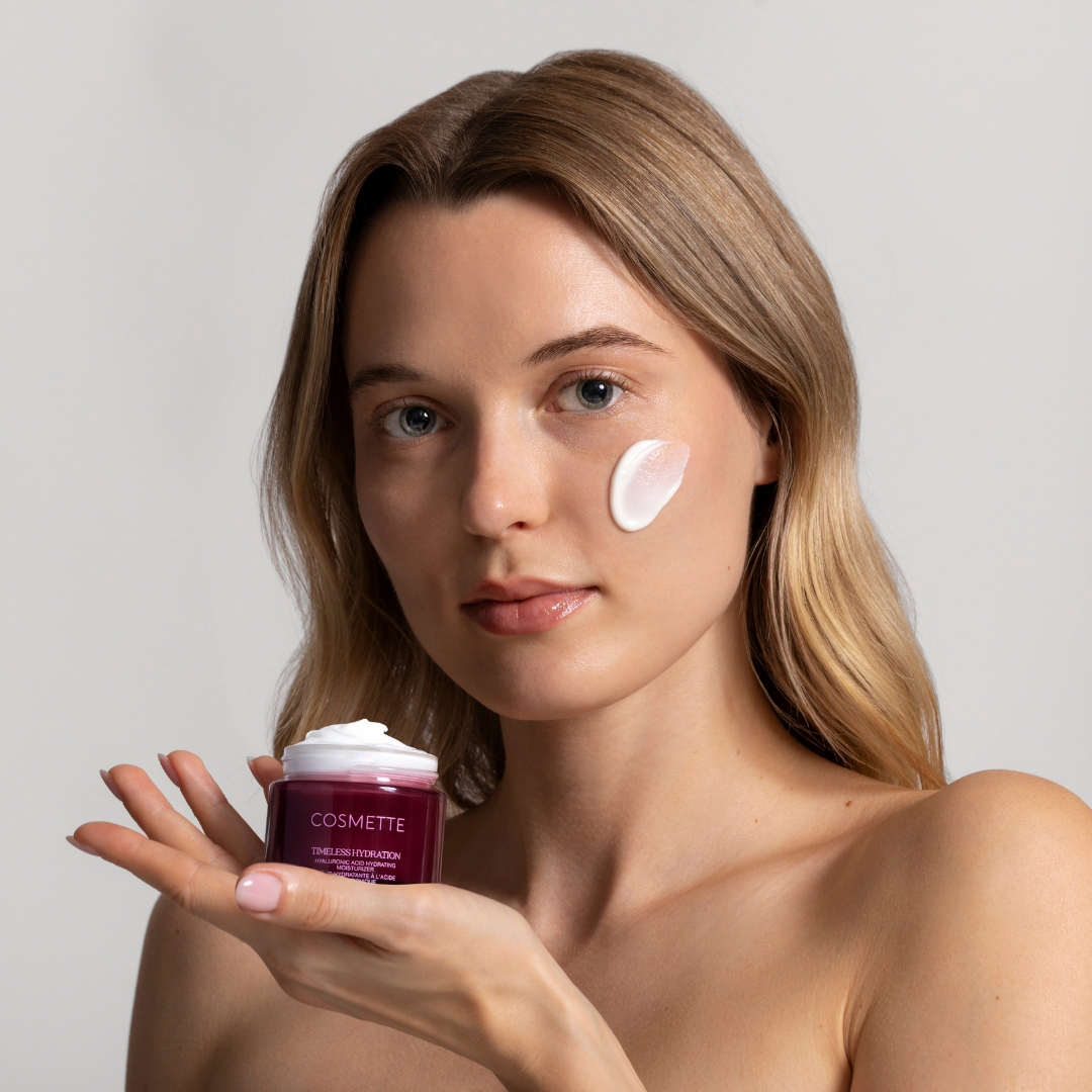 Fair-skinned model holding up a box of Timeless Hydration hyaluronic acid face cream
